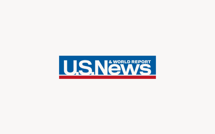 US News and World Report logo with blue text on light pink background, featuring a red horizontal line underneath.