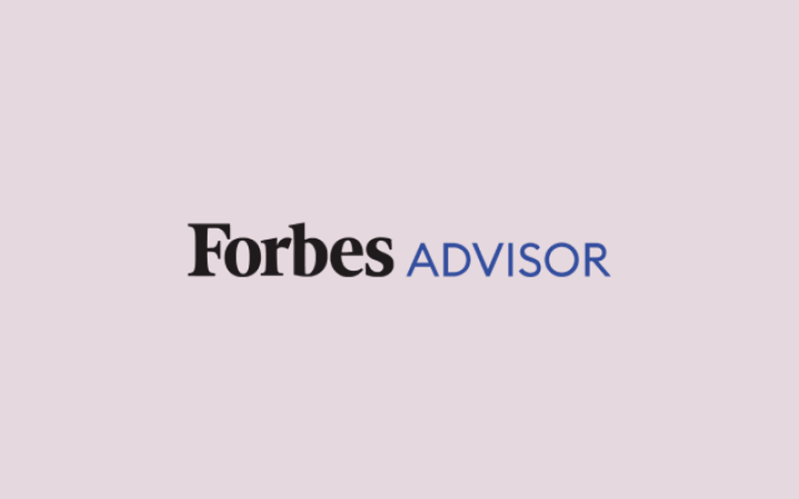 Logo von Forbes Advisor mit schwarzem Text „Forbes“ und blauem Text „ADVISOR“ auf rosa Hintergrund.
