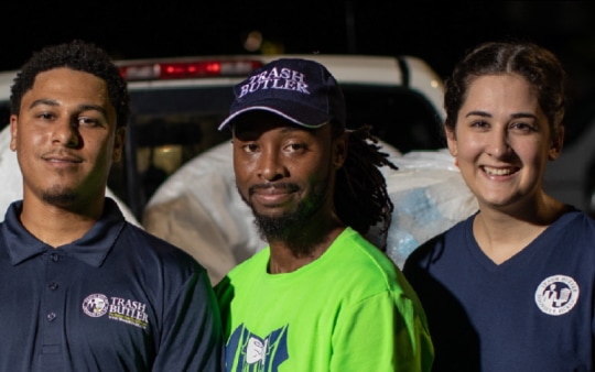 Photograph of three smiling Trash Butler employees