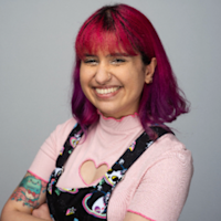 Arta, who has pink and purple hair, smiling. 