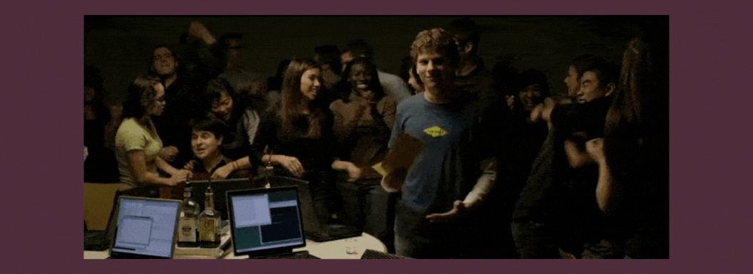 A group of people celebrating with laptops to the side.  
