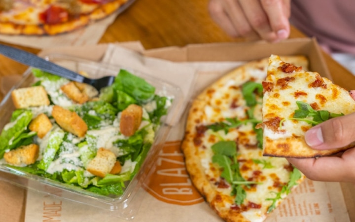 Photograph of a pizza and salad from Blaze Pizza