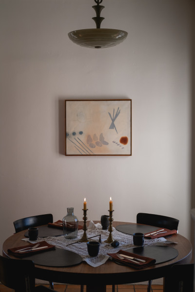 Table is adorned with a vintage lace textile from Josie's collection, Peter Speliopoulos Placemats and Napkins, JB Blunk Cups, Lisa Eisner Candle Snuffer, and Carafe by R+D Lab. The painting, titled "Diana" is by Dan Bruinooge. 