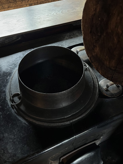 Traditional rice cooking vessel above wood stove