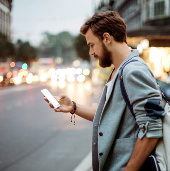 A person is using the TELUS SmartHome+ app and reviewing footage from their Outdoor Camera while on the way home from work.