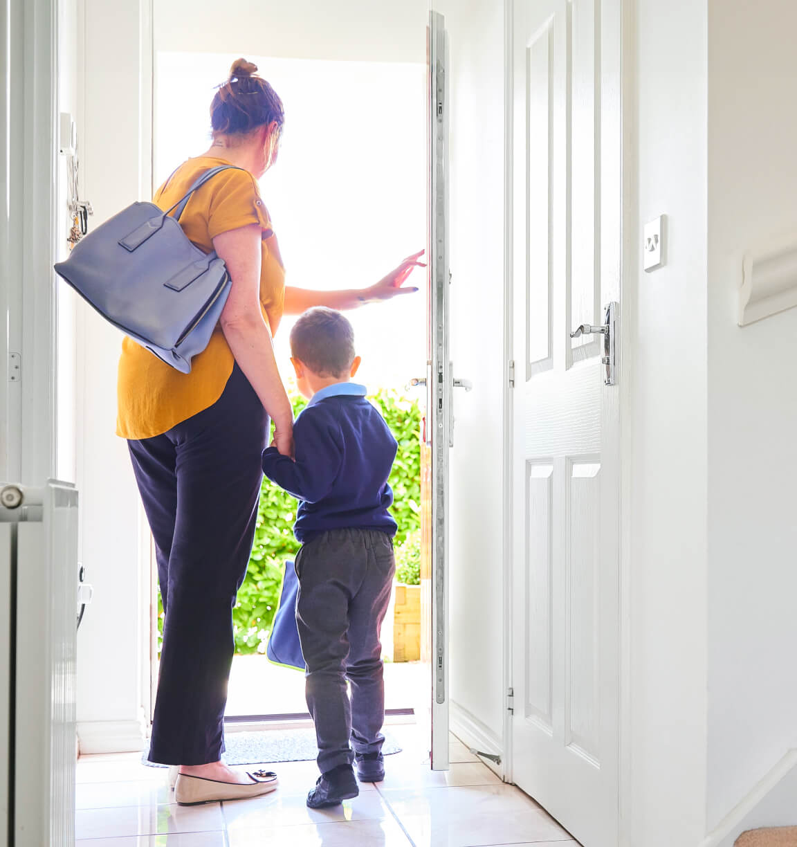 A mother and child leave the house while TELUS SmartEnergy automatically adjusts the temperature while they are away. 