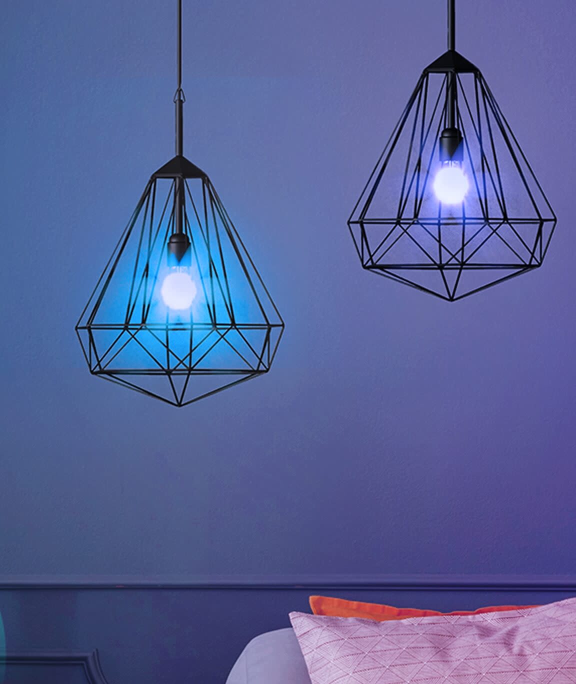 Two multicolour Kasa smart bulbs hanging in pendant fixtures, displaying blue and white lighting in bedroom.