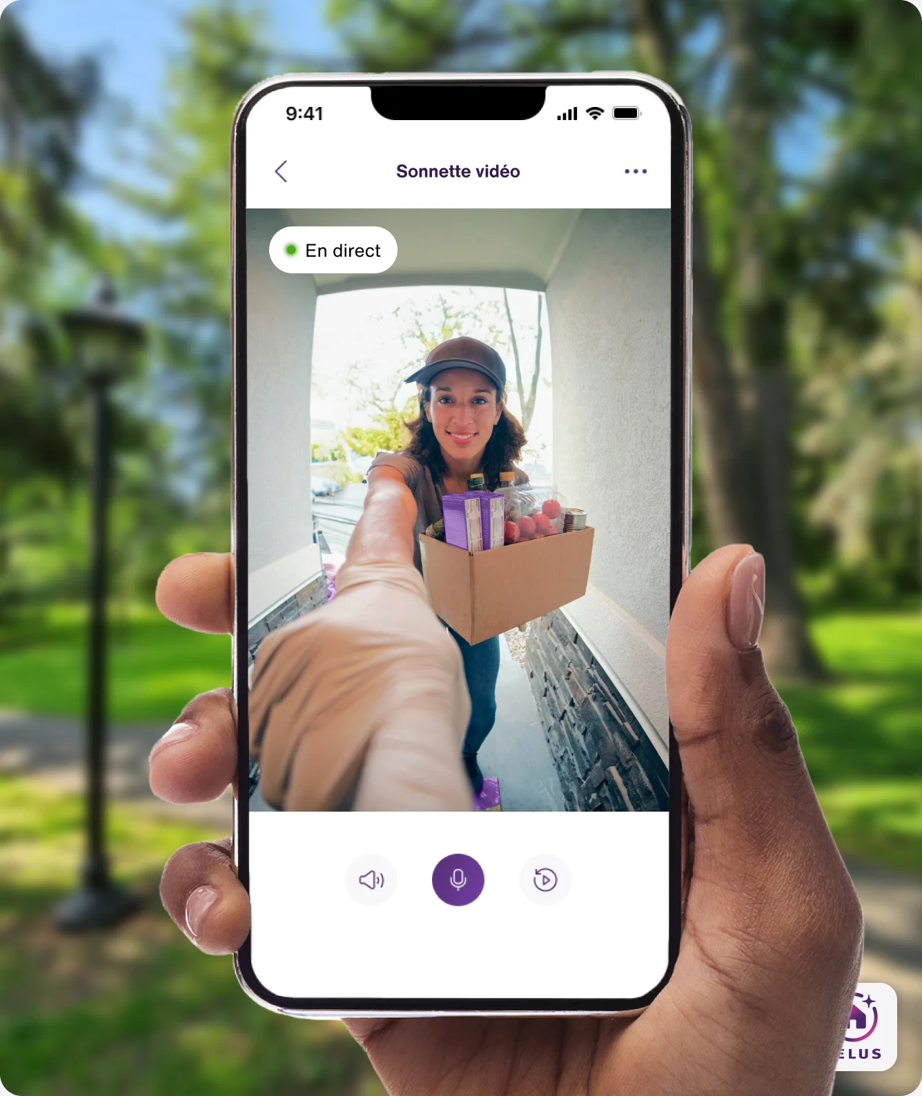 Une main tient l’application TELUS MC+, qui affiche une vidéo en direct d’une personne livrant un colis, observée par la sonnette vidéo TELUS.