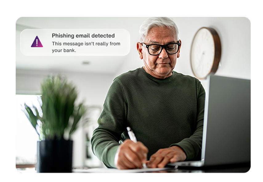 Older man using laptop with Phishing email detected alert warning email is not from his bank.