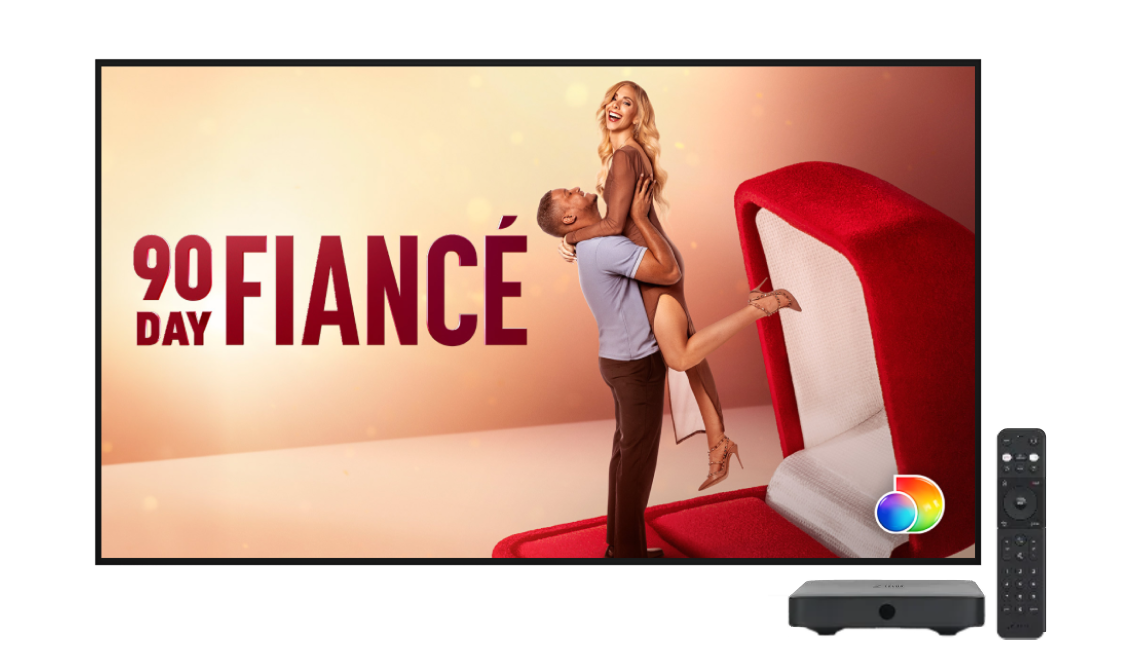Promotional image for the TV series “90 Day Fiance” featuring a smiling woman being lifted by a man beside an open red red ring box, with Discovery+ loco in the bottom right corner.