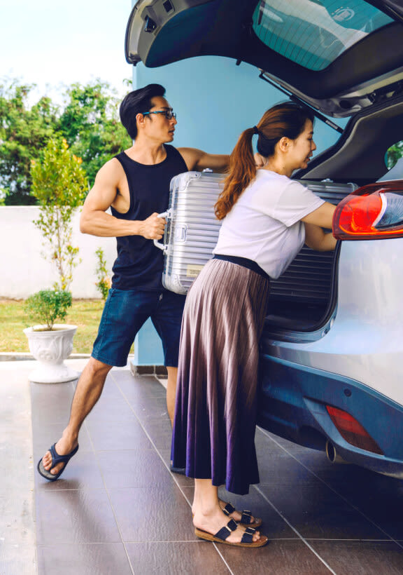 A couple is packing their car for a road trip.