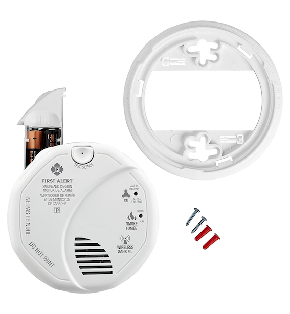 First Alert ZCOMBOA detector with battery compartment open showing two AA batteries for wireless operation convenience