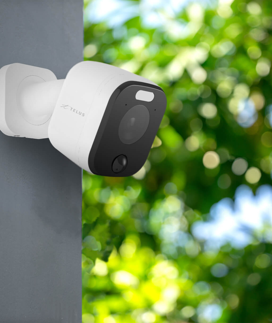 A TELUS Outdoor Camera is seen mounted on the side of a home.