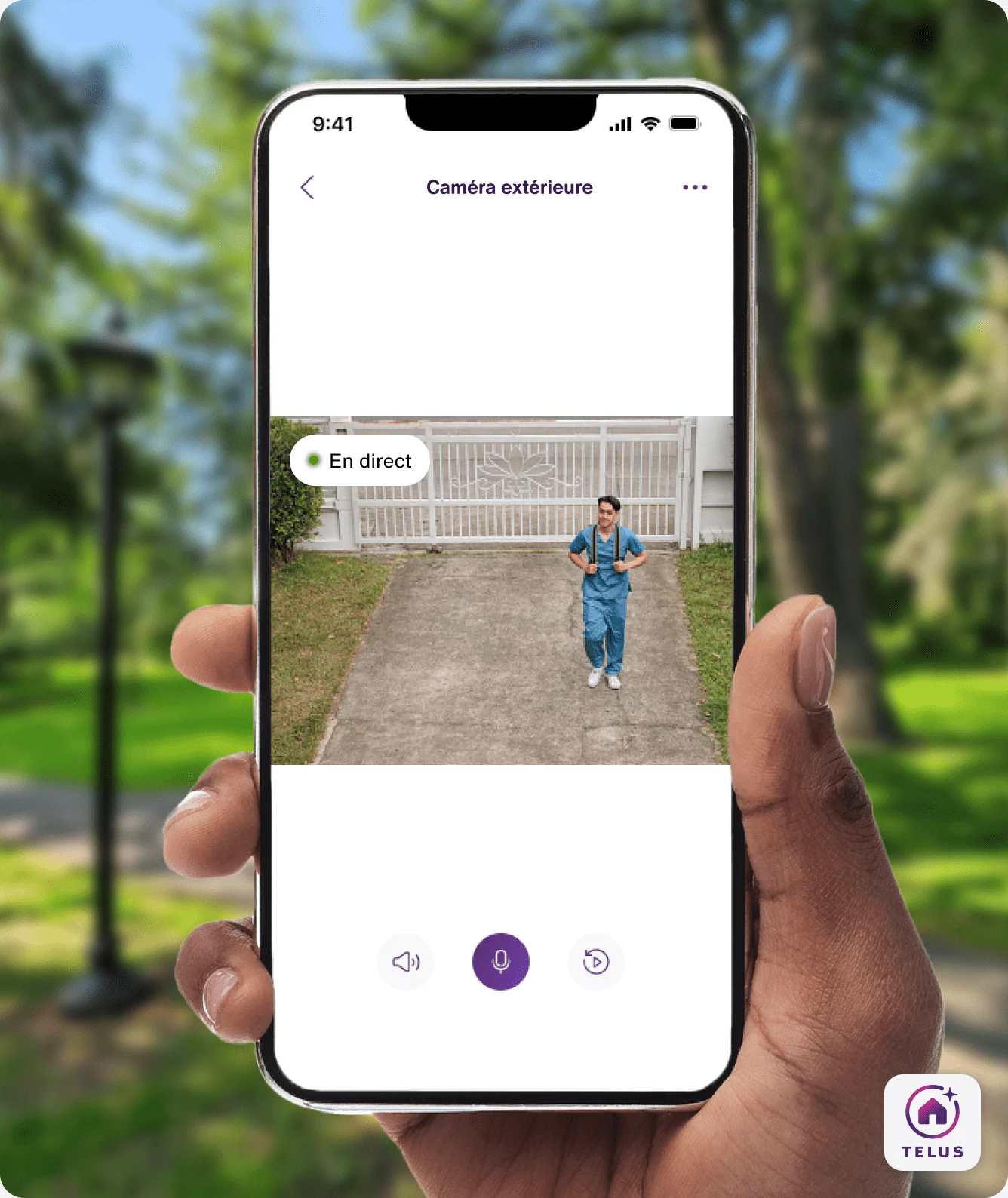 Une main tient  l’appli TELUS MC+, qui montre un visiteur observé par la caméra extérieure TELUS.