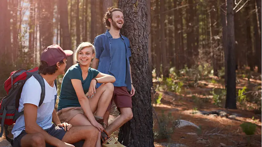 A group of people hiking together surrounded by trees