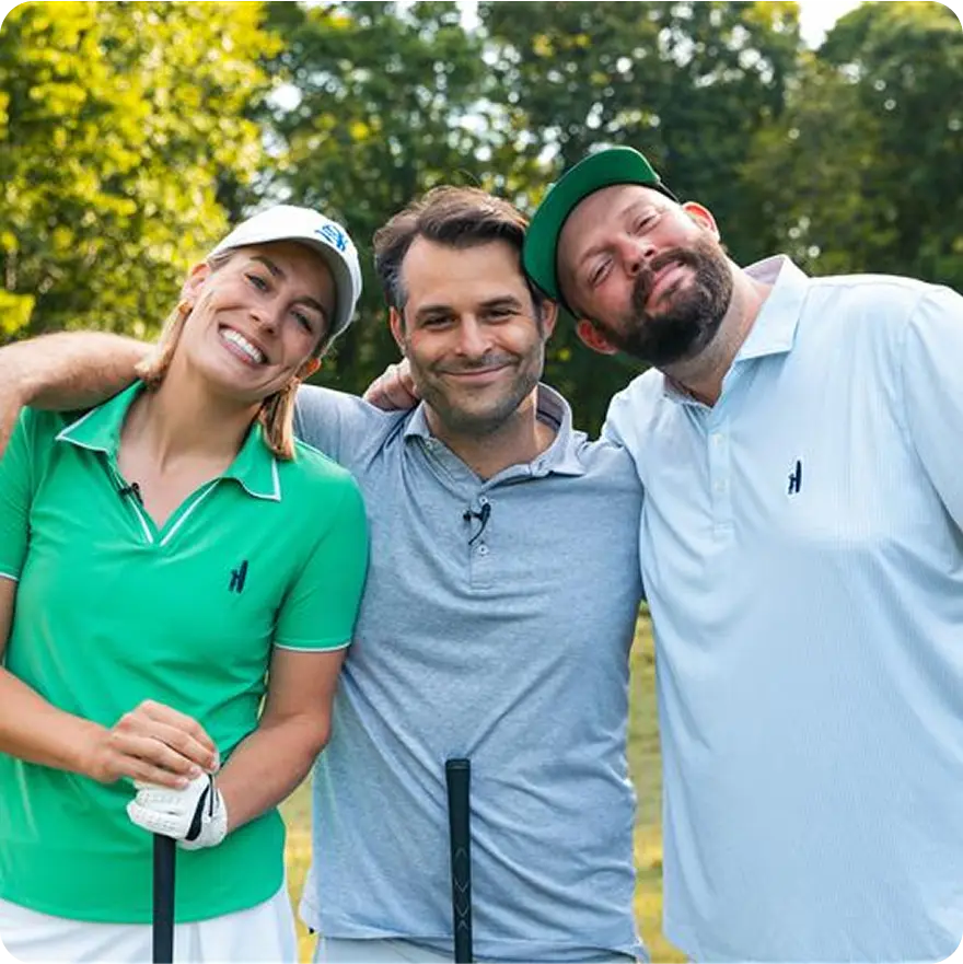 Aaron Chewning, Hannah Rae Aslesen and Jonathon Pawlowski, members of St. Andre Golf, posing for a photo wearing polo shirts and holding golf clubs on a golf.