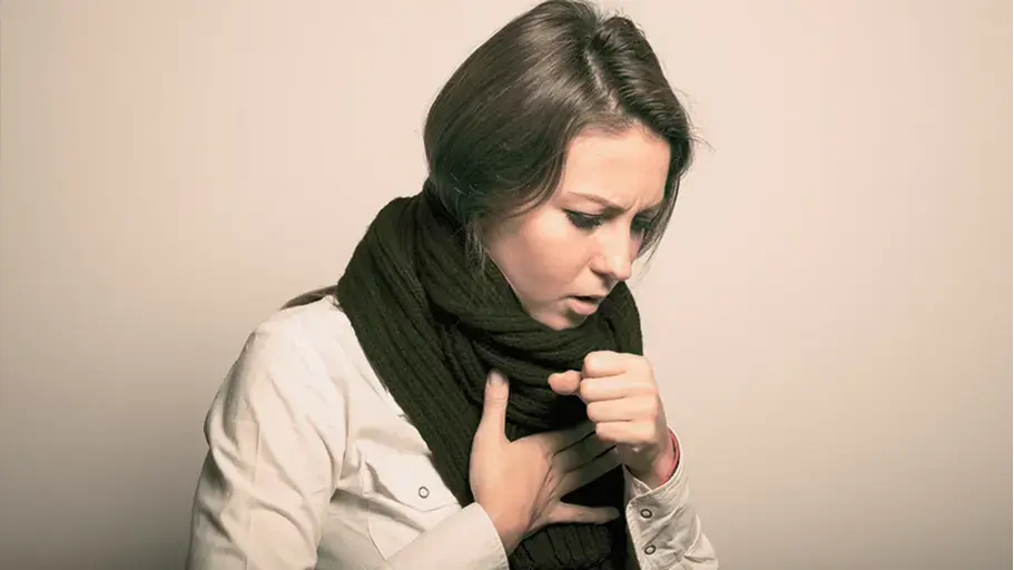 Person wearing a scarf clutching their chest experiencing congestion