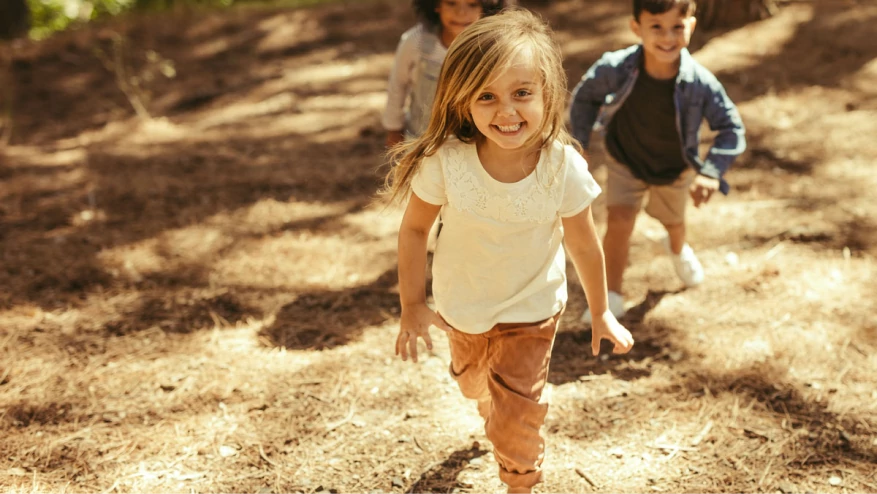 Two happy children playing together outside during the day.