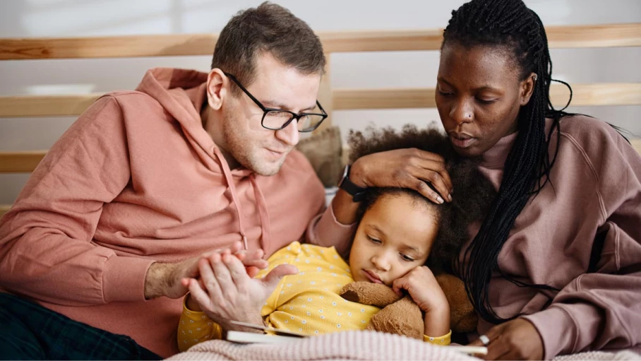 Couple reading with their daughter