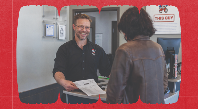 Belle Tire employee assisting a customer at the counter, military discount signage in background.