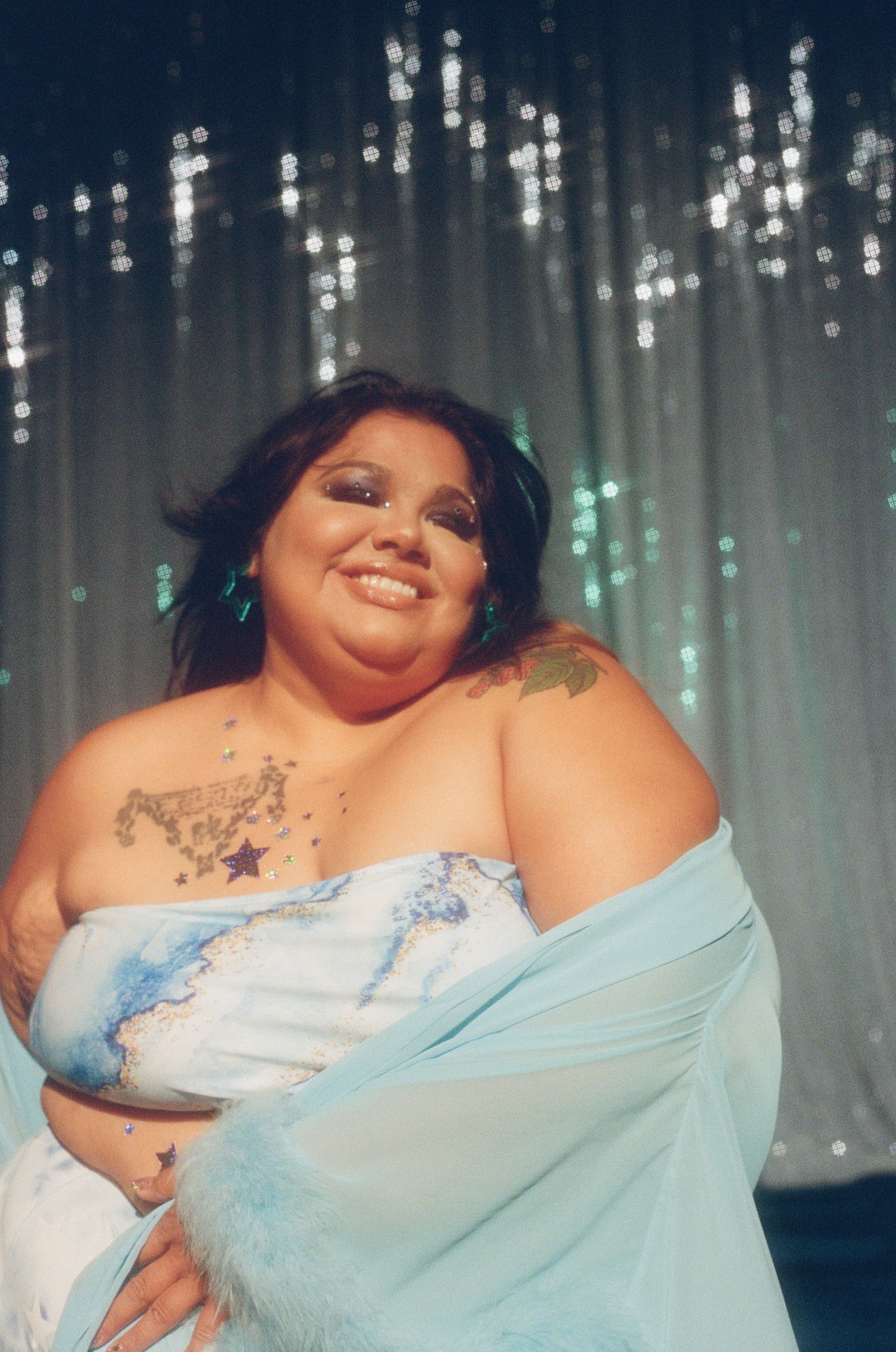 Headshot of Yolanda Bonnell who is wearing a light blue robe and a blue and white marbled strapless bikini top