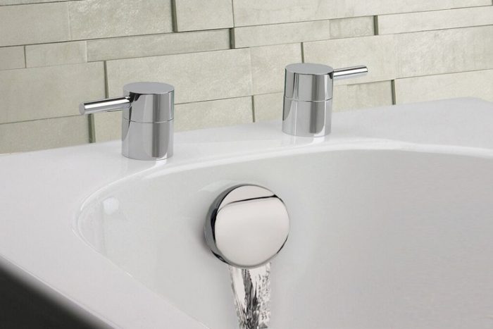 Modern bathroom sink with sleek chrome fixtures and a contemporary backsplash, featuring water flowing from a central outlet