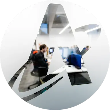 Office workspace viewed through a stylized letter Astrosale A logo, showing computer workstations in a modern environment.
