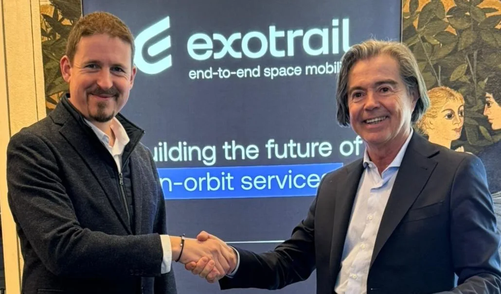 Philippe Blatt, Managing Director of Astroscale France and Jean-Luc Maria, CEO of Exotrail shaking hands in front of an Exotrail display about space mobility and in-orbit services.