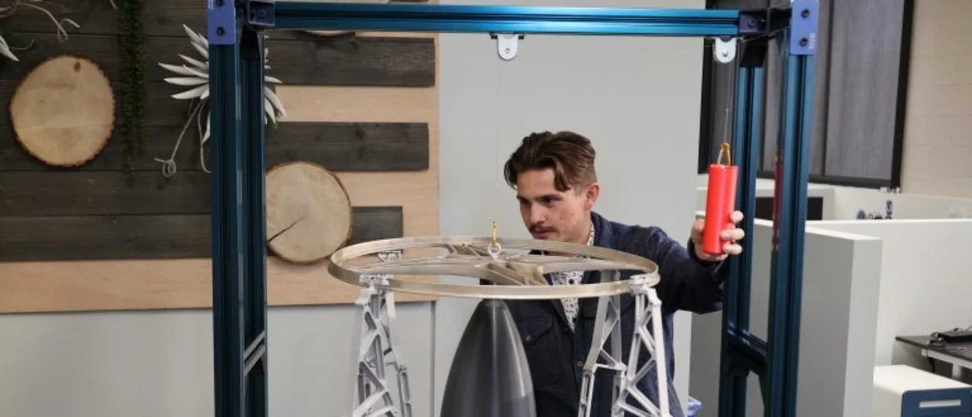 An Astroscale U.S. intern demonstrates his docking arms model