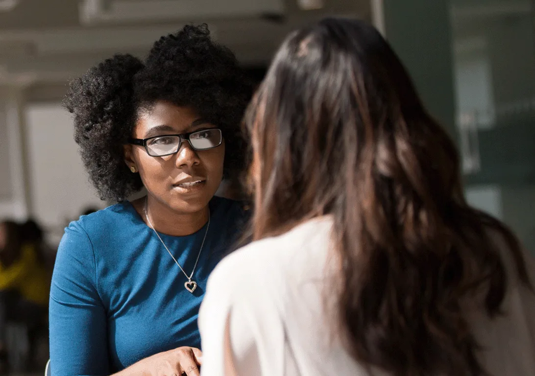 Two women facing each other having a conversation