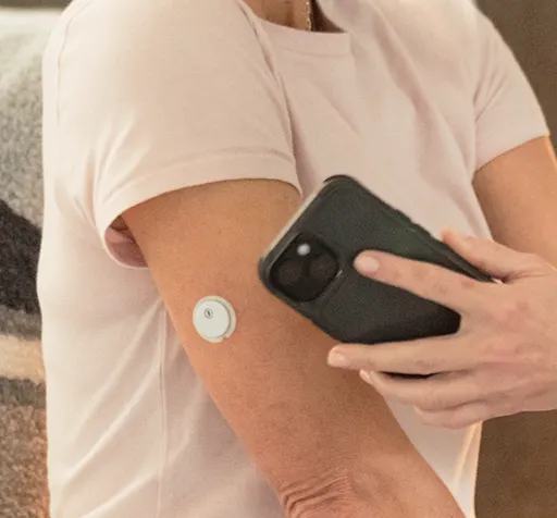A person wearing the FreeStyle Libre 3 Plus CGM on their arm