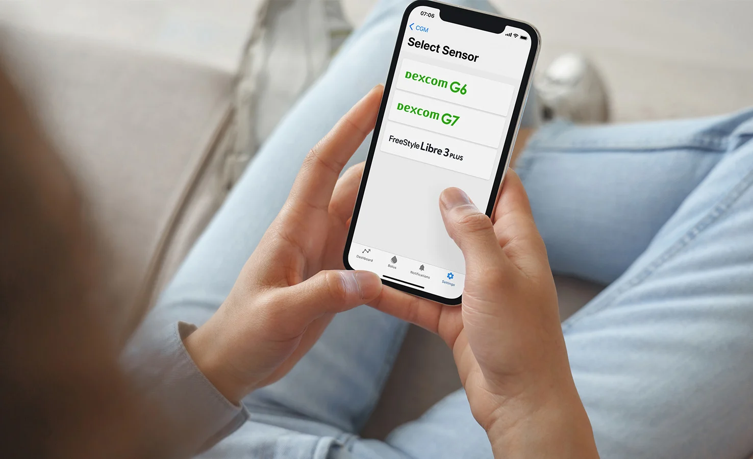 Person looking at the Tandem t:slim Mobile App on their phone with options to pair their CGM