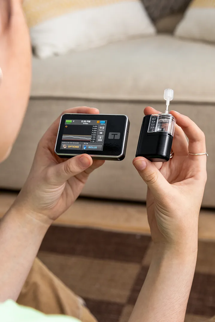 Izzy holding the t:slim X2 and Tandem Mobi pumps next to each other