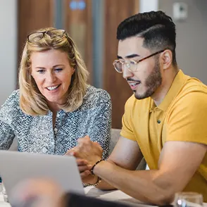 Two employees looking at a laptop screen