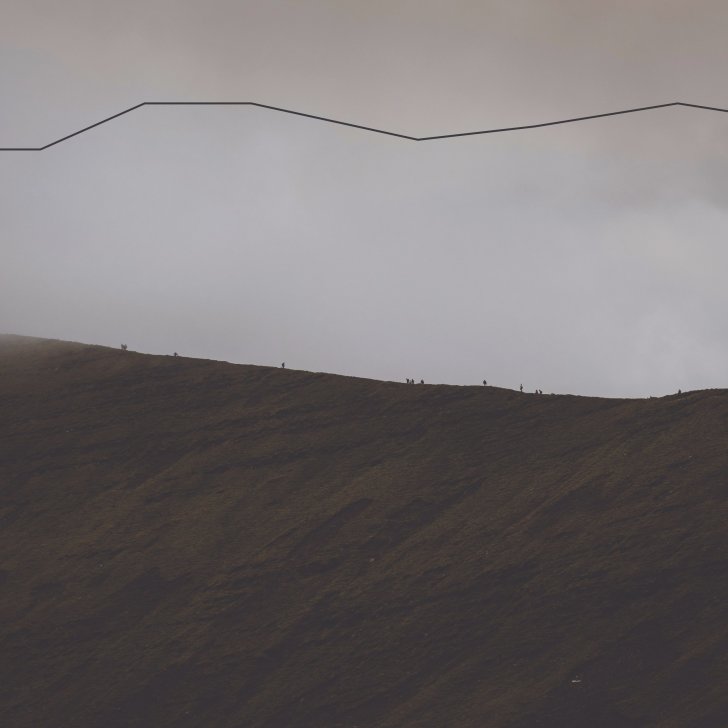 Image of a mountain with people on top very small