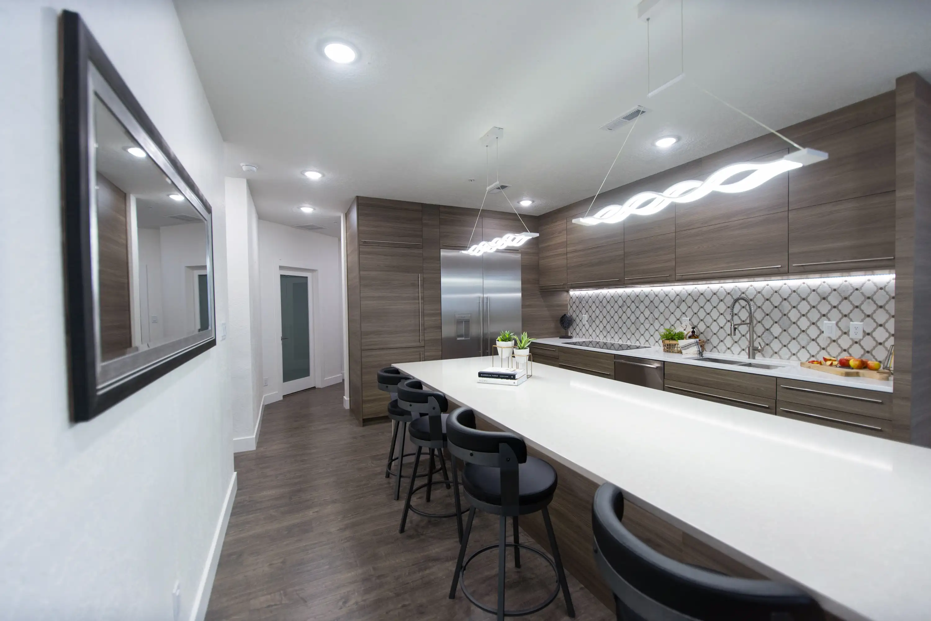 A kitchen with all matching wood cabinetry and flooring throughout. A white countertops contrasts against the rest of the kitchen. 