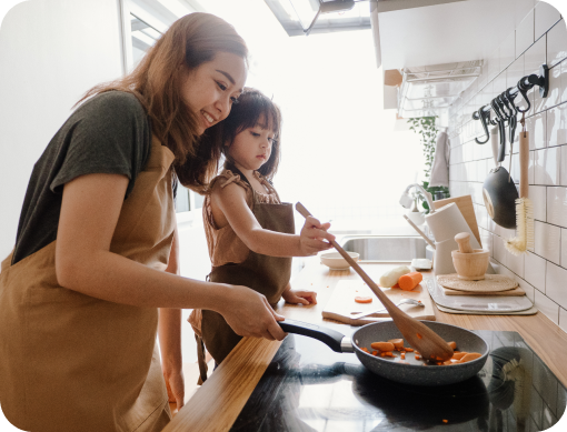 Mom and young daughter cooking.