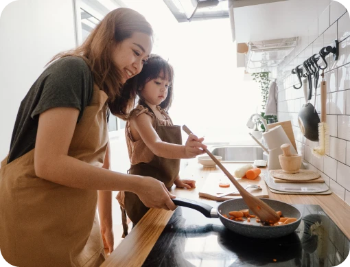 Mom and young daughter cooking.