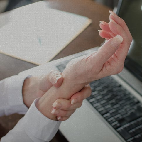 Close-up of a person holding their wrist, suggesting wrist pain or discomfort