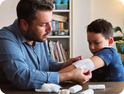 Dad bandaging his son’s arm.
