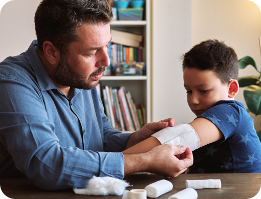 Dad bandaging his son’s arm.