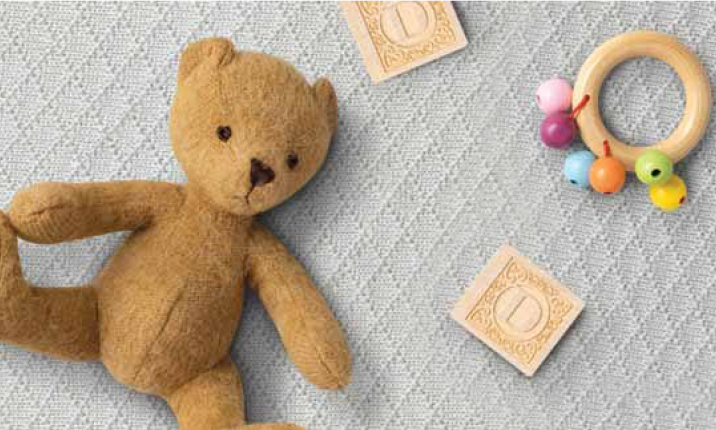 Teddy bear on the left, rattle on the right, text in the center: 'First choice of pediatricians in the diaper rash category. Comfort restored.'