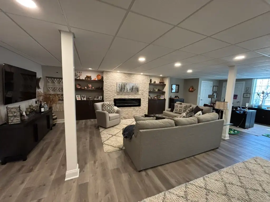 Denville NJ Basement 1 - Completed - Wide view of new living space with fireplace and floor detail Denville NJ Basement 1 - Completed - Wide view of new living space with fireplace and floor detail