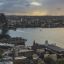Panoramic view of sydney skyline featuring the harbour bridge and opera house with a stormy sky in the background.