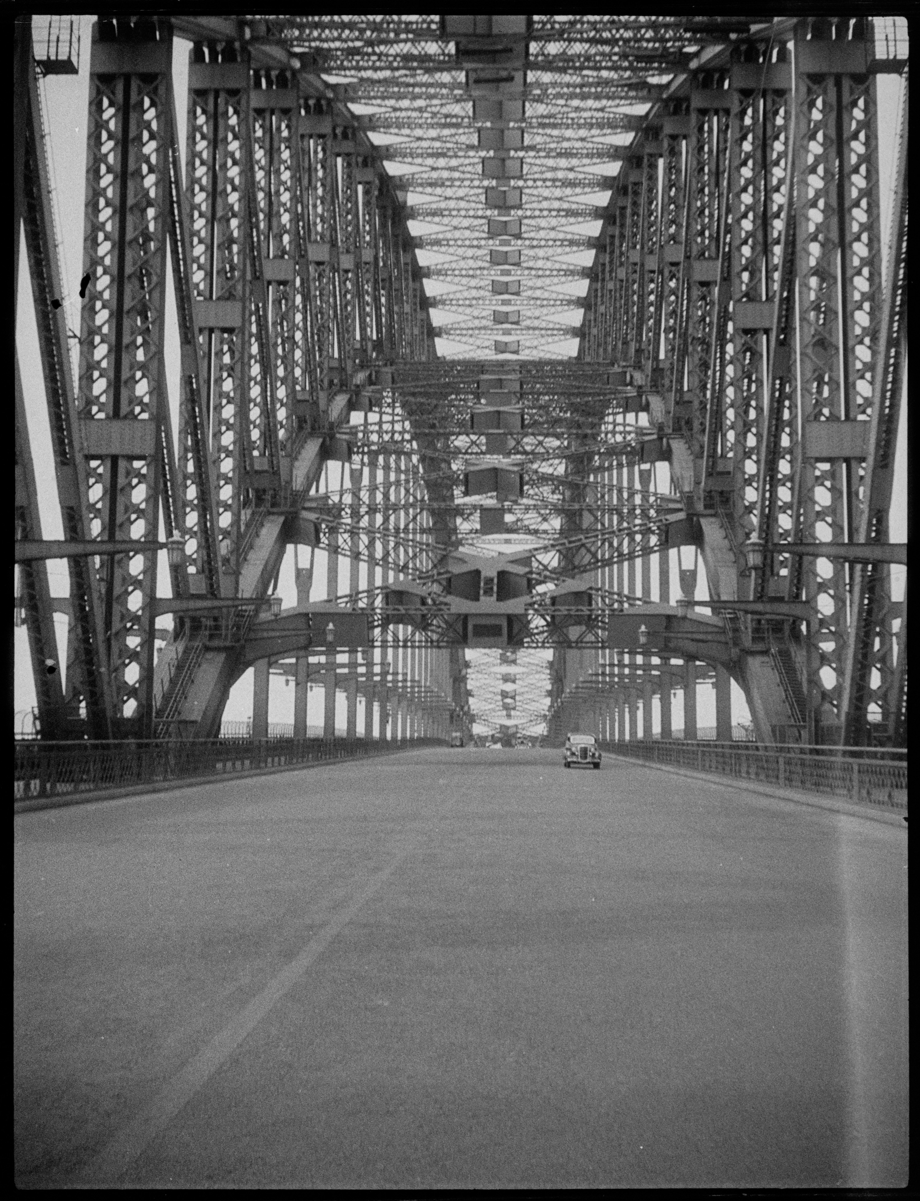 A handful of cars drive across the Sydney Harbour Bridge in this photo, taken sometime in 1937. Bryant's position as a shop steward and union leader gave him something of a privileged position when it came to access on the bridge, allowing him to capture so many unique photos. Photo: Percy James Bryant / City of Sydney Archives A-01141929 