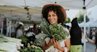 Young woman farmers market kale leek
