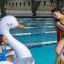 Two people enjoying leisure time at an indoor swimming pool with an inflatable swan.