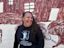 Jinny-Jane Smith stands in front of the Redfern mural 'Mission Boy Dreams' which is based on an etching by Wiradjuri artist Roy Kennedy. It depicts his memories of the Warangesda Mission in the Riverina where his family is from. It’s also the Aboriginal reserve where Jinny-Jane’s grandmother Margaret comes from.

