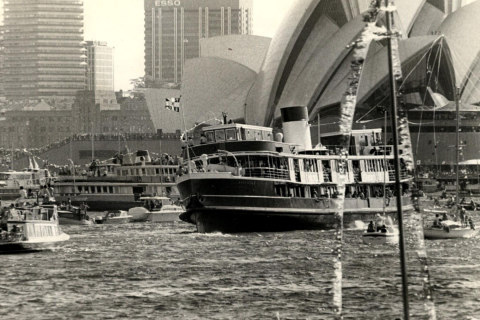 The harbour teems with boats for the official opening of the Sydney Opera House. In the foreground the ferry Baragoola tilts as the crowds on board line the starboard side for a better view. Photo: Graeme Andrews, City of Sydney Archives, A-00075516.