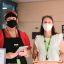 2 staff members at City of Sydney library wearing masks and pictured with QR code for check in